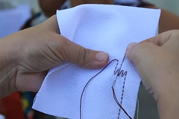 Mãos bordando um tecido